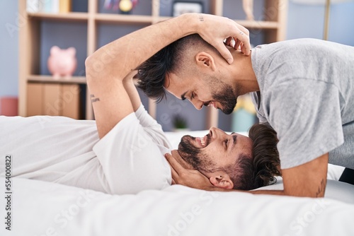 Young couple hugging each other lying on bed at bedrooom photo