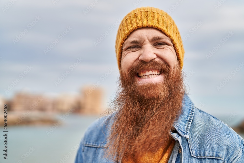 Young redhead man smiling confident standing at seaside