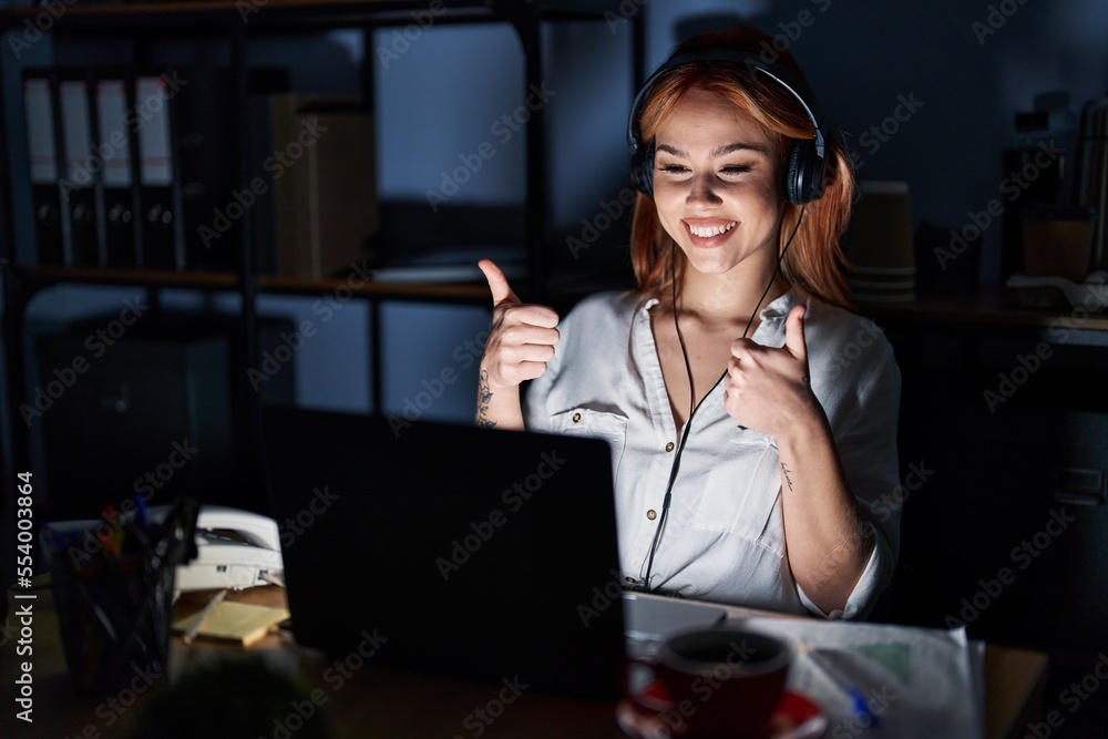 Young caucasian woman working at the office at night success sign doing positive gesture with hand, thumbs up smiling and happy. cheerful expression and winner gesture. Young caucasian woman working at the office at night success sign doing positive gesture with hand, thumbs up smiling and happy. cheerful expression and winner gesture.