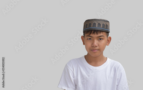 Portrait Asian young Muslim or Isamic boy wears hat and white shirt, soft and selective focus. photo