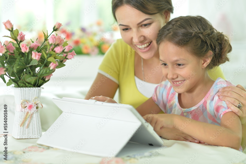 mother and daughter using tablet together at home mother and daughter using tablet together at home