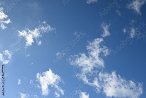 Fondo natural con detalle de varias nubes de tonos blancos y cielo azul con degradado de luz