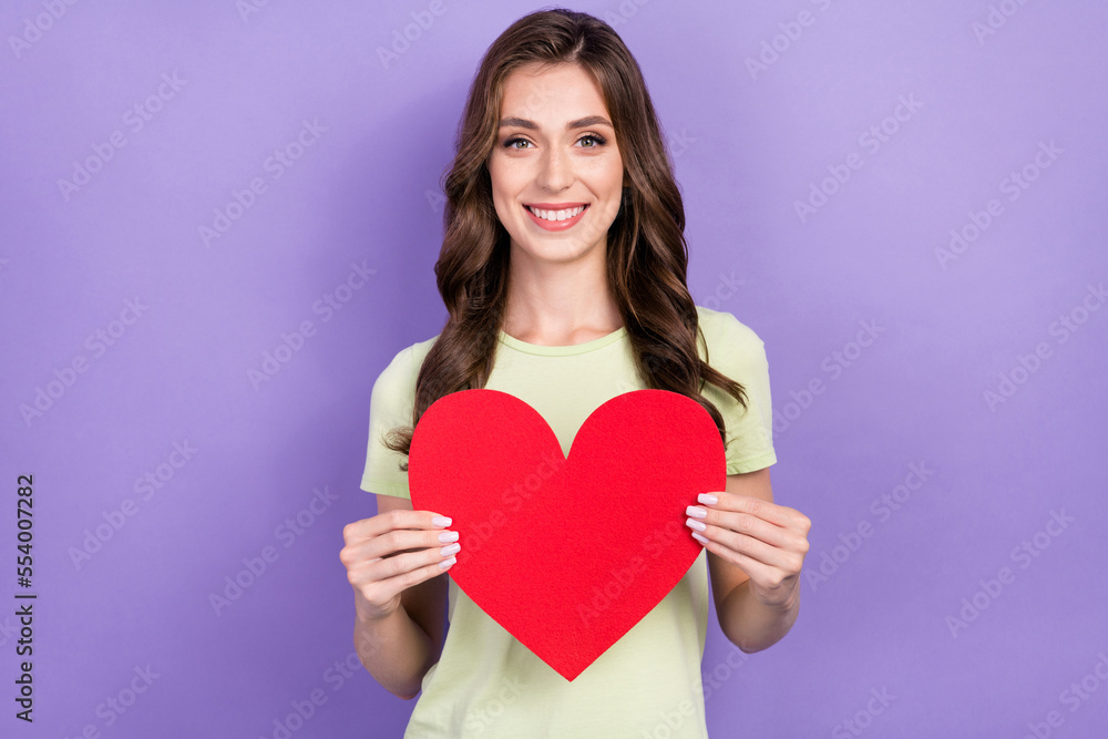 Photo of young smiling good mood brunette hair lady hold big red paper love symbol want gift from her boyfriend isolated on violet color background Photo of young smiling good mood brunette hair lady hold big red paper love symbol want gift from her boyfriend isolated on violet color background