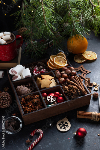 On the table there is a box with nine compartments in which nuts, cookies and spices are poured