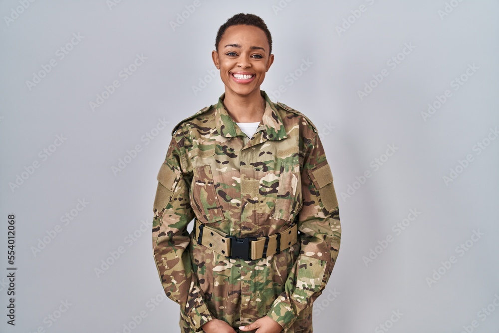 Beautiful african american woman wearing camouflage army uniform with a happy and cool smile on face. lucky person.