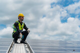 technician engineer working on checking maintenance service with solar batteries near solar panels at sunny day in solar power plant station on rooftop, electricity energy of photovoltaic industrial
