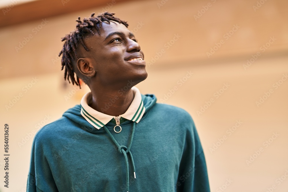 Fototapeta premium African american man smiling confident looking to the sky at street