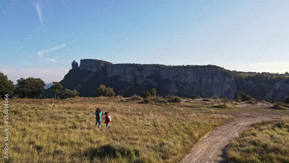 Drone view of a couple walking with their dog on a rural mountain trail. Drone view of a couple walking with their dog on a rural mountain trail.