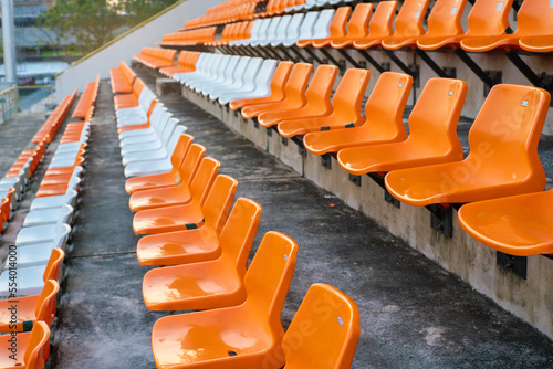 Orange white stadium chairs in outdoor field