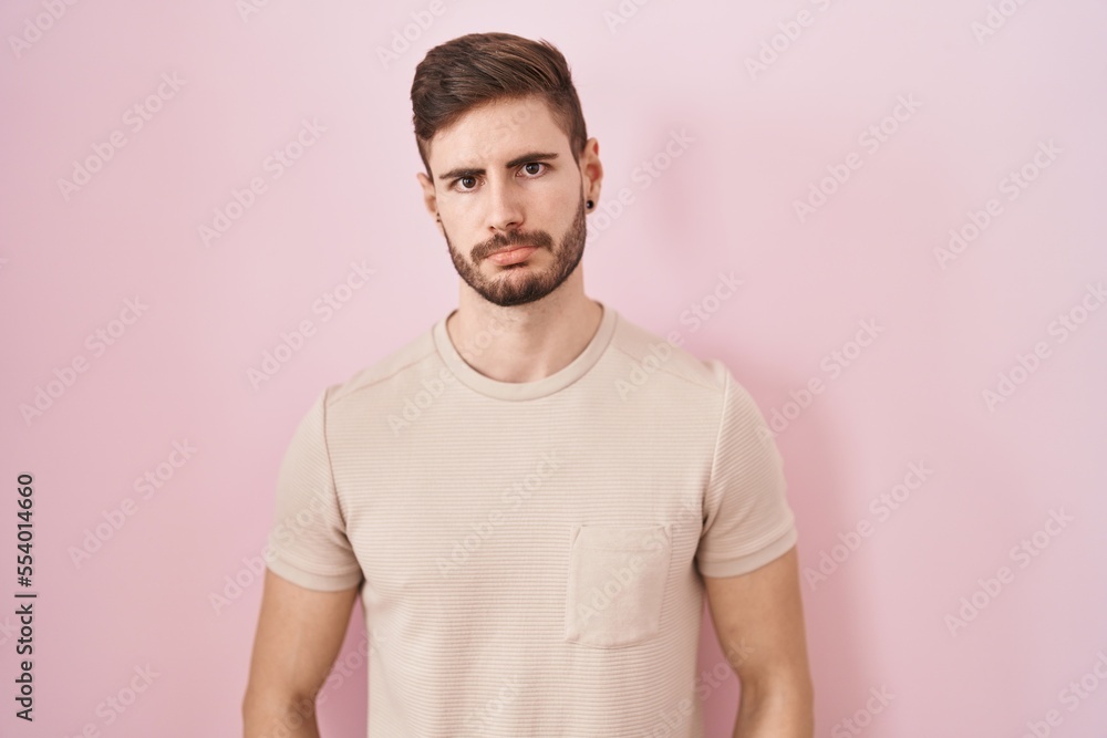 Hispanic man with beard standing over pink background depressed and worry for distress, crying angry and afraid. sad expression. Hispanic man with beard standing over pink background depressed and worry for distress, crying angry and afraid. sad expression.