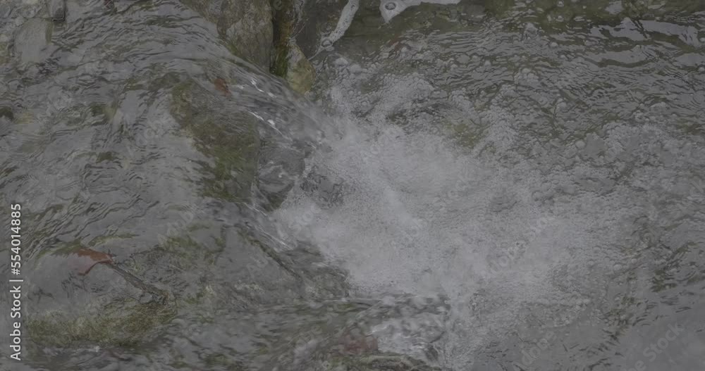 Water flowing between rocks on a mountain stream in slow motion detail 4K F-LOG video format Water flowing between rocks on a mountain stream in slow motion detail 4K F-LOG video format