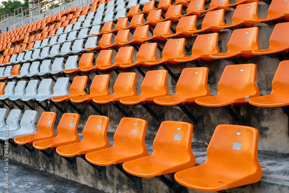 Orange white stadium chairs in outdoor field