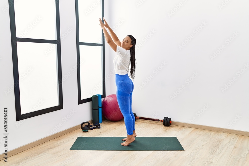 Young african american woman smiling confident stretching at sport center