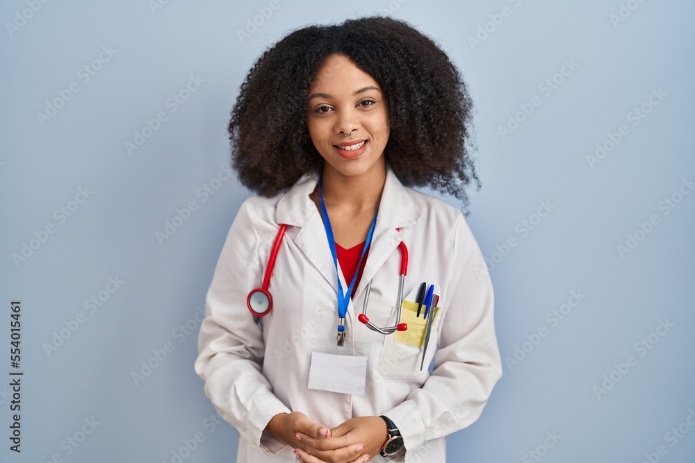 Young african american woman wearing doctor uniform and stethoscope with hands together and crossed fingers smiling relaxed and cheerful. success and optimistic Young african american woman wearing doctor uniform and stethoscope with hands together and crossed fingers smiling relaxed and cheerful. success and optimistic