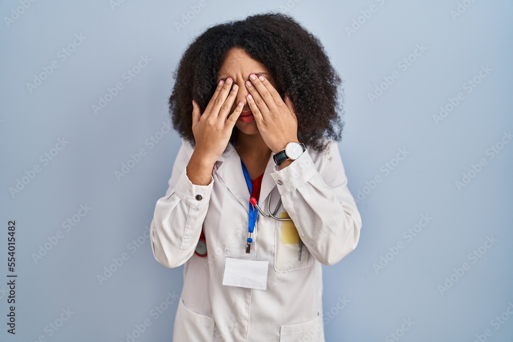 Young african american woman wearing doctor uniform and stethoscope rubbing eyes for fatigue and headache, sleepy and tired expression. vision problem Young african american woman wearing doctor uniform and stethoscope rubbing eyes for fatigue and headache, sleepy and tired expression. vision problem