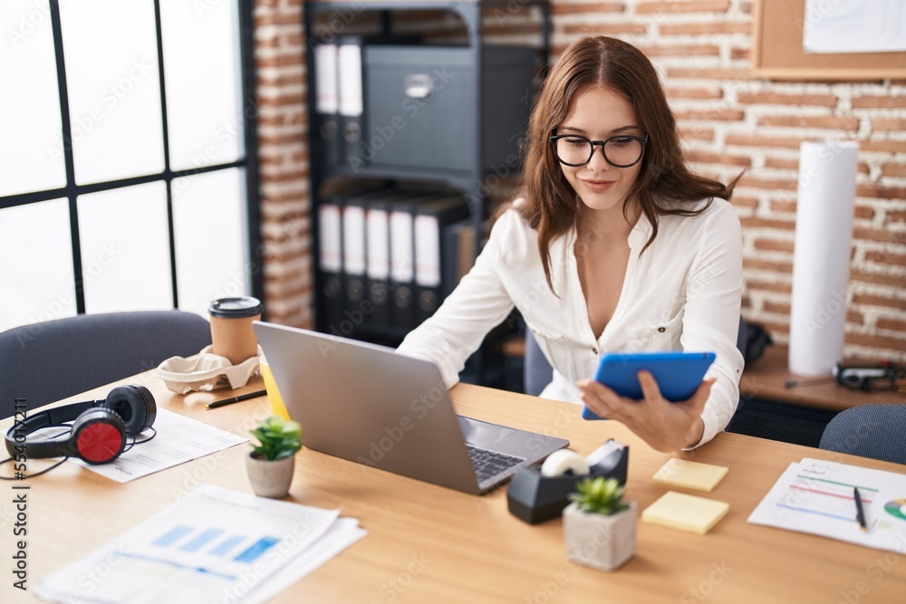 Young woman business worker using laptop and touchpad at office Young woman business worker using laptop and touchpad at office