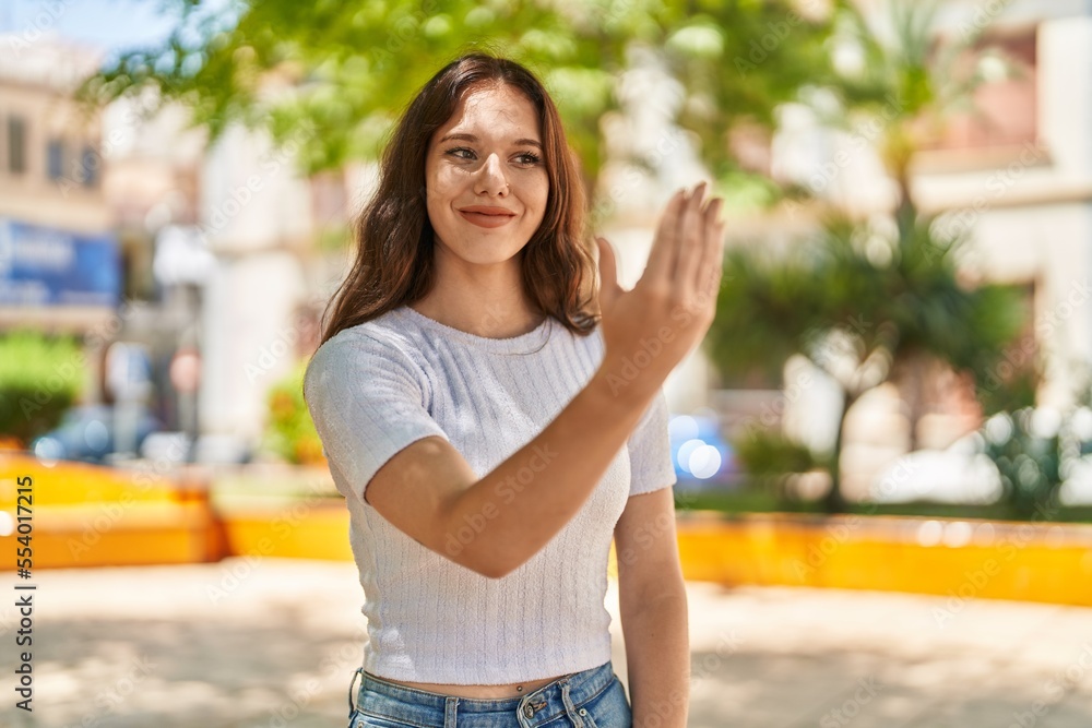Young woman smiling confident doing coming gesture with hands at park Young woman smiling confident doing coming gesture with hands at park