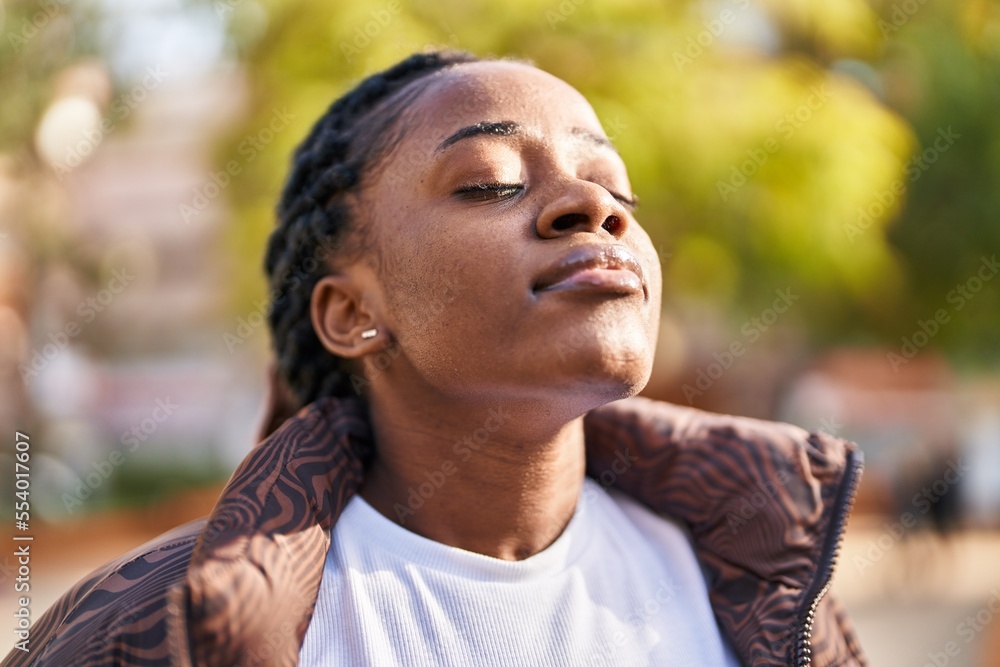 African american woman breathing with closed eyes at park African american woman breathing with closed eyes at park