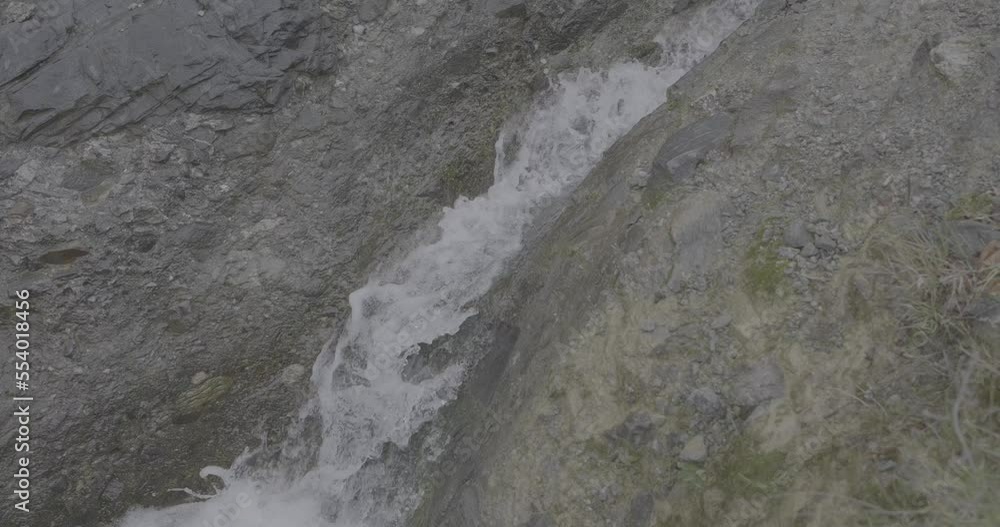 Water flowing between rocks on a mountain stream in slow motion detail 4K F-LOG video format Water flowing between rocks on a mountain stream in slow motion detail 4K F-LOG video format