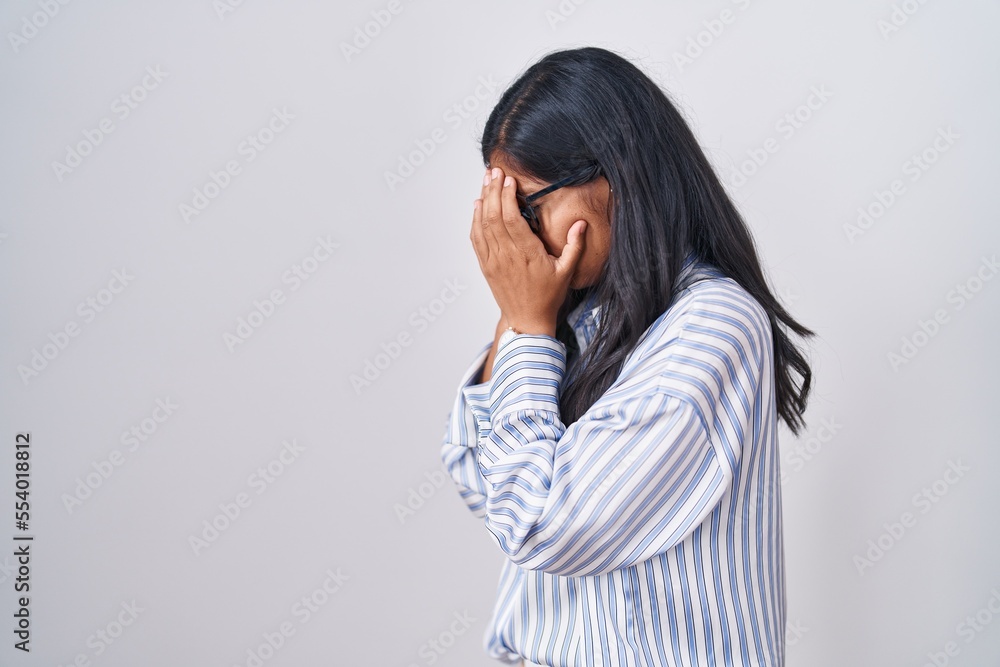 Young hispanic woman wearing glasses with sad expression covering face with hands while crying. depression concept. Young hispanic woman wearing glasses with sad expression covering face with hands while crying. depression concept.