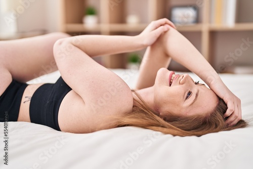 Young caucasian woman smiling confident lying on bed at bedroom