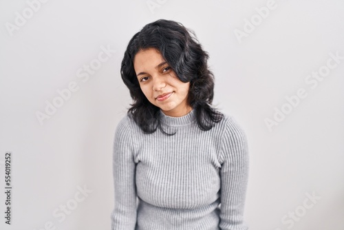 Hispanic woman with dark hair standing over isolated background looking sleepy and tired, exhausted for fatigue and hangover, lazy eyes in the morning.