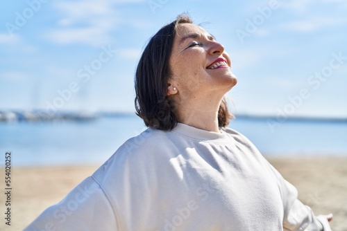 Middle age woman smiling confident breathing at seaside © Krakenimages.com