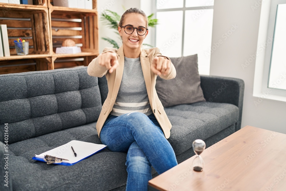 Young woman working at consultation office pointing to you and the camera with fingers, smiling positive and cheerful Young woman working at consultation office pointing to you and the camera with fingers, smiling positive and cheerful