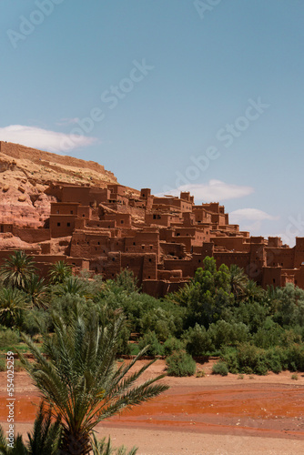 Ait Ben Haddou city, desert village with palms and yellow stones and rocks, castle in sahara desert, canyon, Morocco