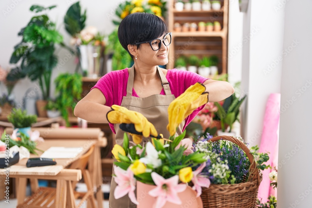 Middle age chinese woman florist cutting plants at flower shop Middle age chinese woman florist cutting plants at flower shop