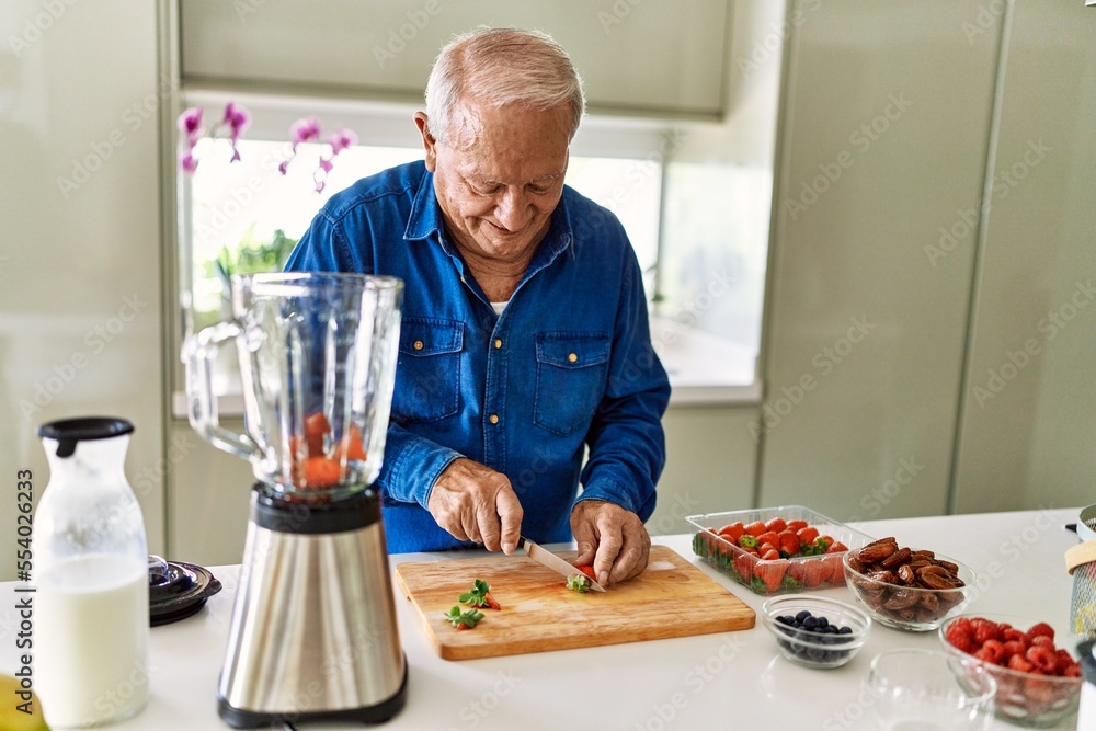 Senior man smiling confident cutting strawberry at kitchen Senior man smiling confident cutting strawberry at kitchen