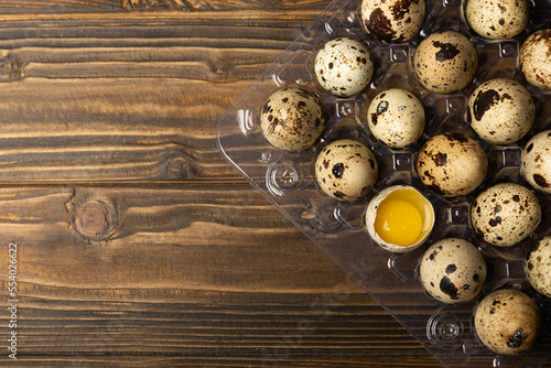 Quail eggs in a plastic package on a dark brown wooden background. Healthy food. Diet. top view. free space.