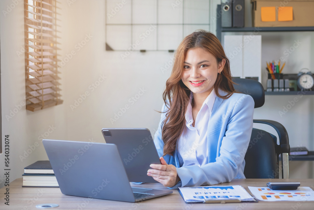 Marketing, finance, accounting, planning, female accountant portrait with beautiful smile wearing team blue suit using laptop calculator and documents, charts, graphs In the company analysis is profit