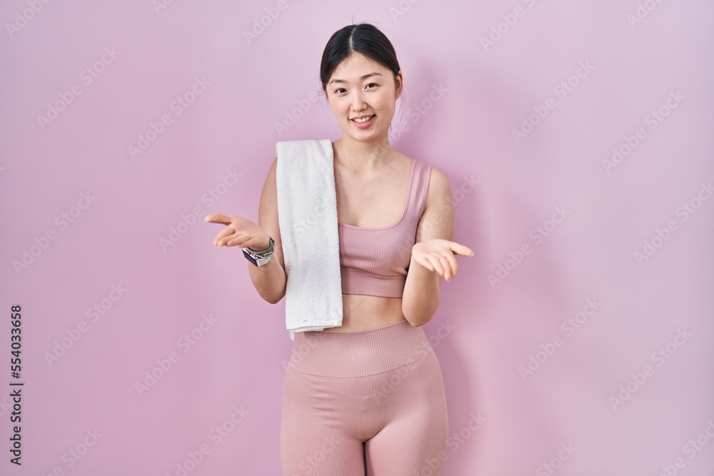 Chinese young woman wearing sportswear and towel smiling cheerful offering hands giving assistance and acceptance. Chinese young woman wearing sportswear and towel smiling cheerful offering hands giving assistance and acceptance.