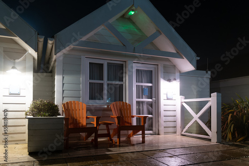Night view of a seaside holiday chalet showing the veranda and twin chairs. Taken during a foggy evening.