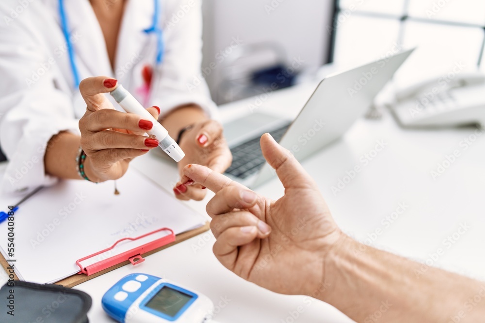 Middle age man and woman wearing doctor uniform measuring glucose at clinic Middle age man and woman wearing doctor uniform measuring glucose at clinic