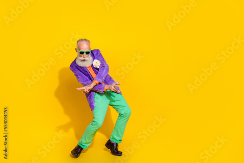 Full length photo of positive charming guy dressed violet velvet jacket dancing disco empty space isolated yellow color background