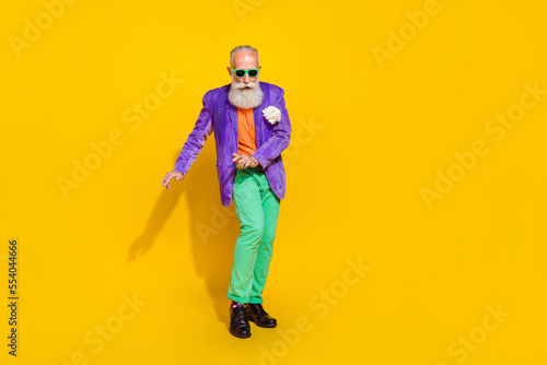 Full length photo of handsome funny man wear purple velvet jacket dancing discotheque isolated yellow color background