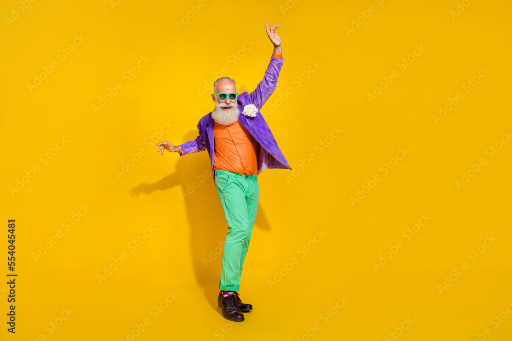 Full length photo of positive cheerful man wear purple velvet jacket sliding legs dancing discotheque isolated yellow color background