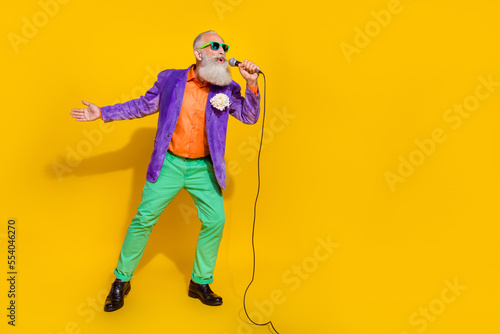 Full length photo of funky excited guy dressed violet velvet jacket singing songs empty space isolated yellow color background photo