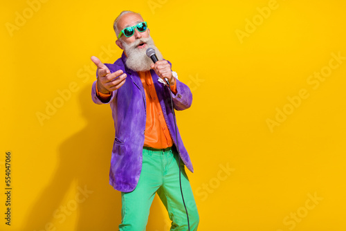 Photography Photo of funny charming man wear purple velvet jacket enjoying karaoke pointing