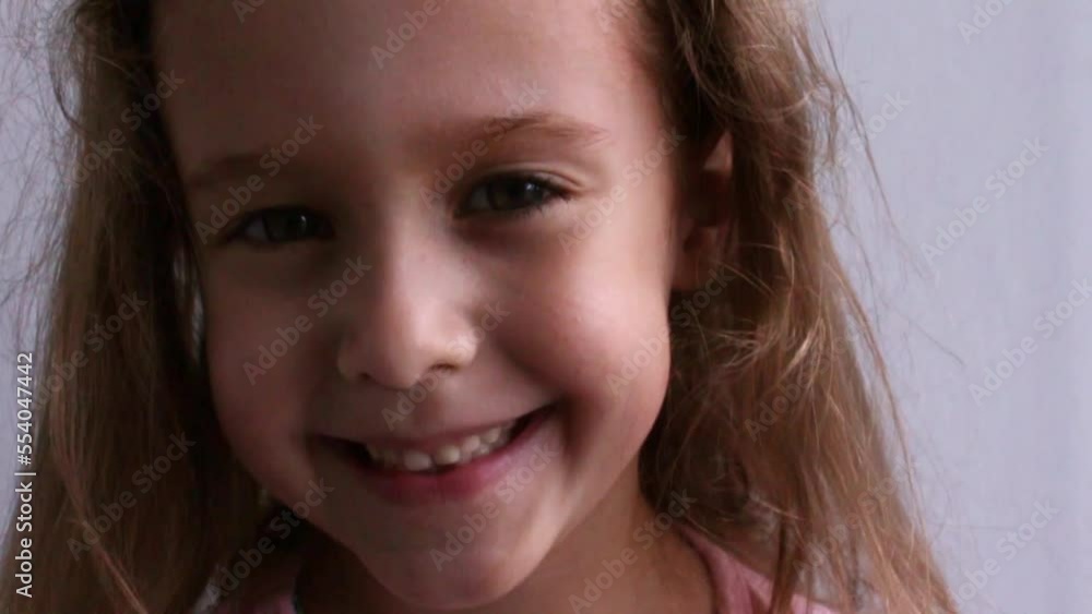 Childish laughing baby close-up portrait. A beautiful little girl smiles at the camera. Video Childish laughing baby close-up portrait. A beautiful little girl smiles at the camera. Video