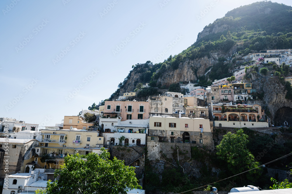 Positano with hotels and houses on hills leading down to coast, comfortable beaches and azure sea on Amalfi Coast in Campania, Italy.