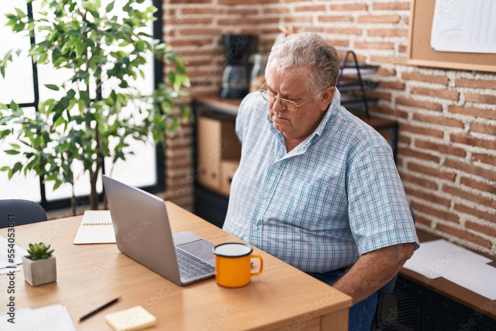 Middle age grey-haired man business worker suffering for backache at office Middle age grey-haired man business worker suffering for backache at office