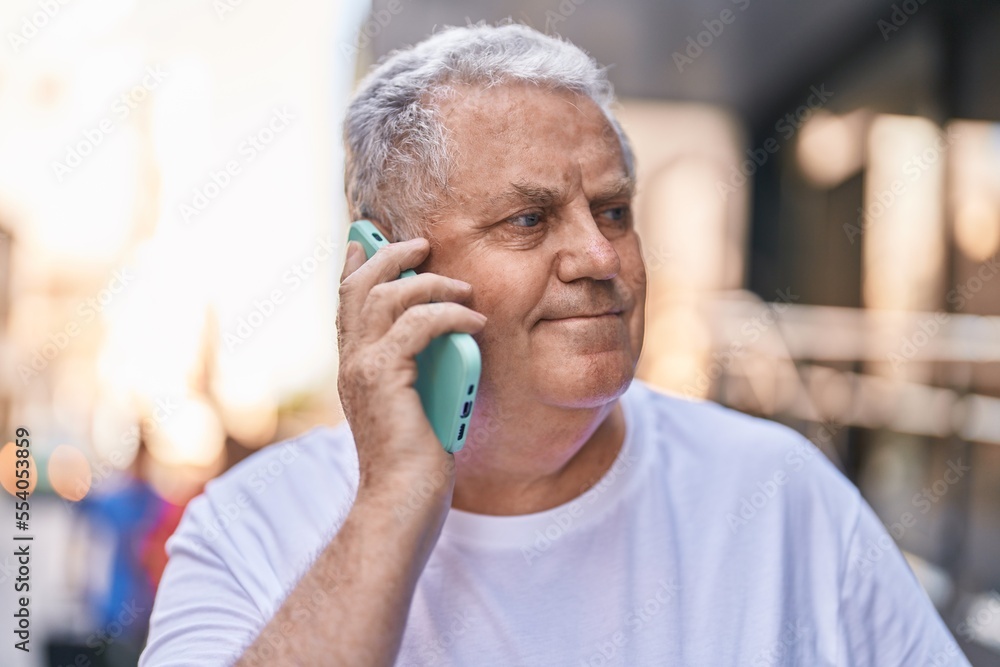 Middle age grey-haired man smiling confident talking on the smartphone at street Middle age grey-haired man smiling confident talking on the smartphone at street