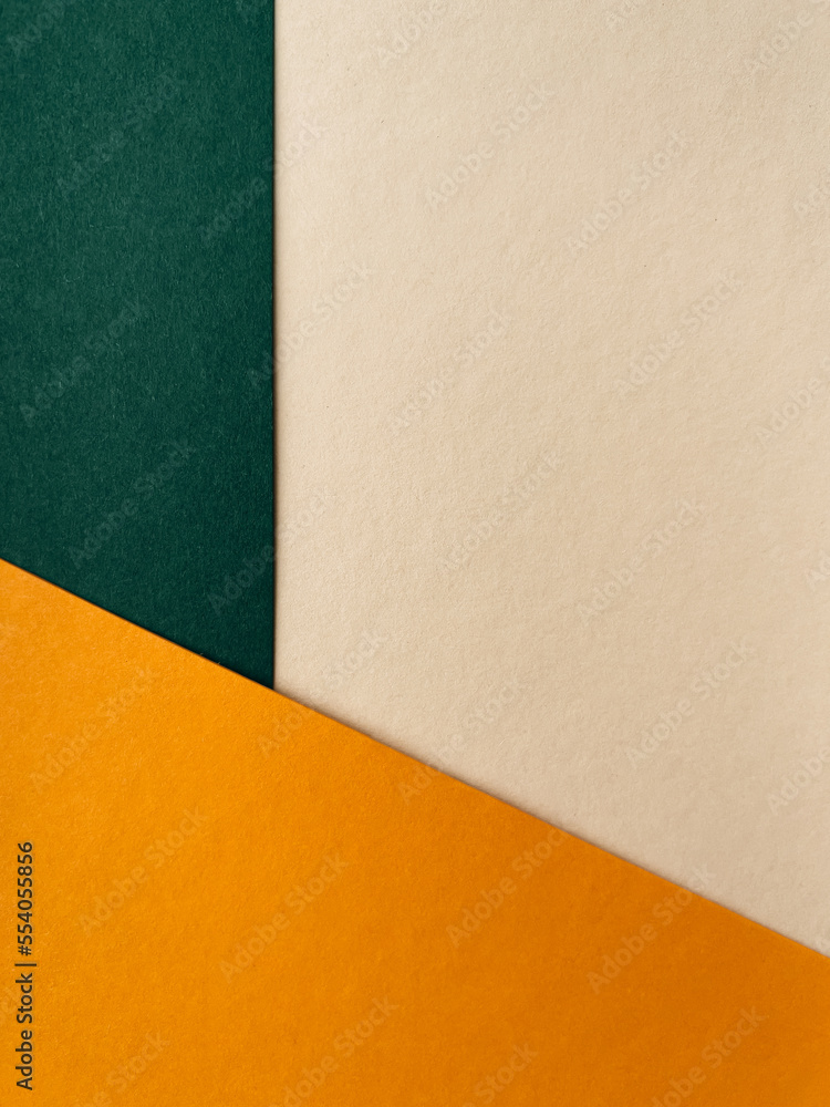 Abstract colourful paper background on office table with texture. Green, beige, orange Abstract colourful paper background on office table with texture. Green, beige, orange