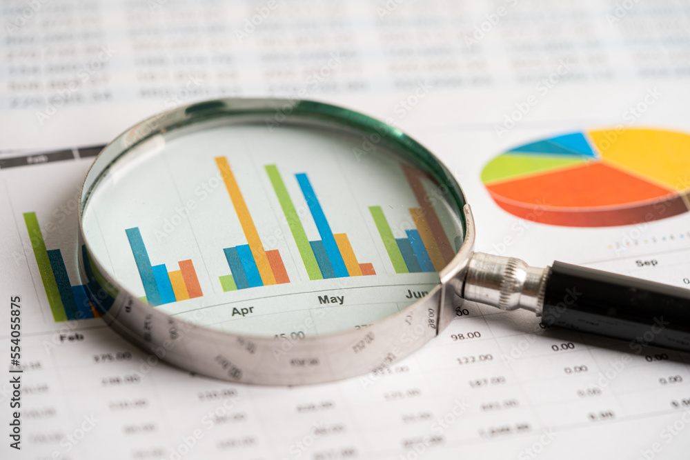 Magnifying glass on charts graphs paper. Financial development, Banking Account, Statistics, Investment Analytic research data economy, Stock exchange trading, Business office concept. Magnifying glass on charts graphs paper. Financial development, Banking Account, Statistics, Investment Analytic research data economy, Stock exchange trading, Business office concept.