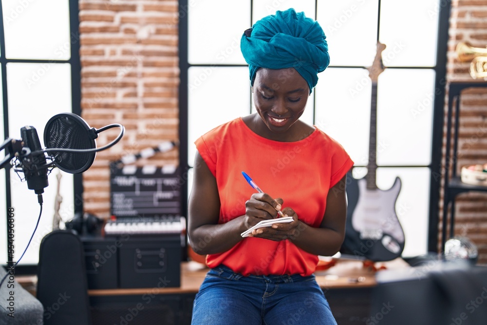 Εκτύπωση καμβά Young african american woman musician composing song at music