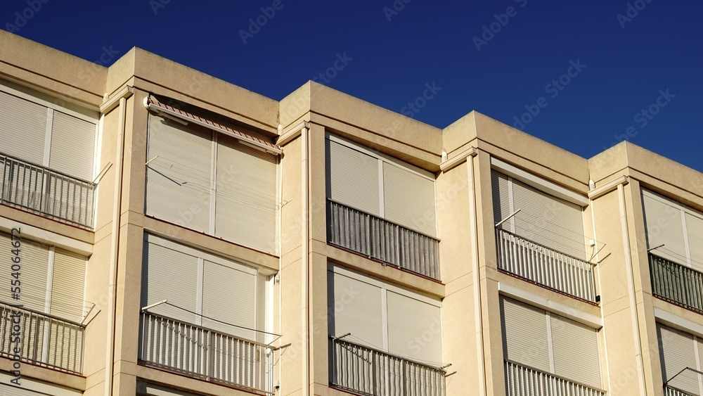 building facade with lowered window shutters building facade with lowered window shutters