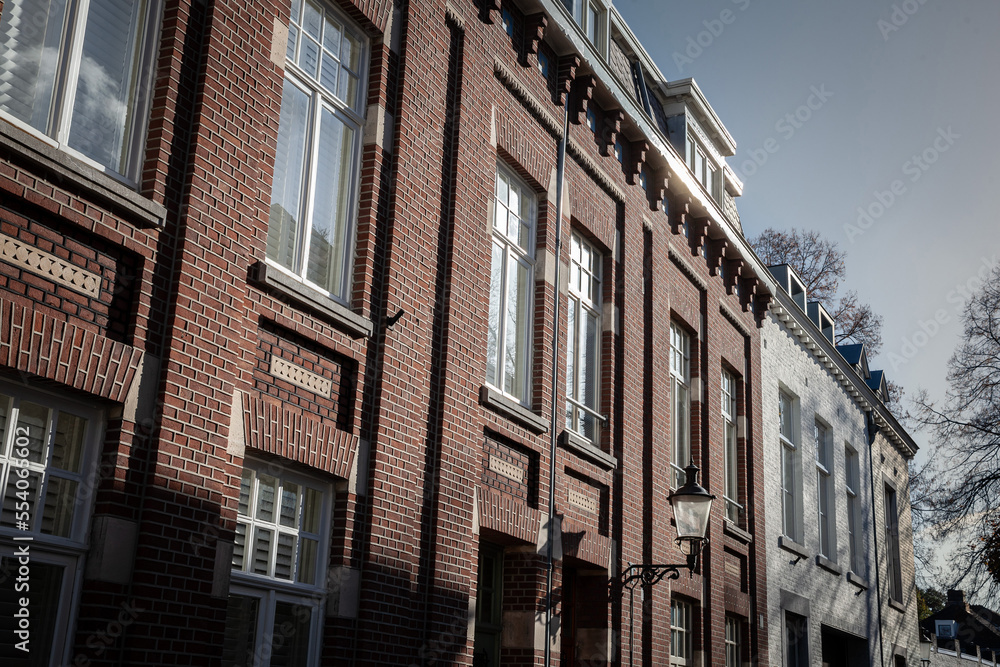 Typical facades of dutch architecture in the city center of Maastricht, Netherlands, with residential buildings, facades of red brick and flats....